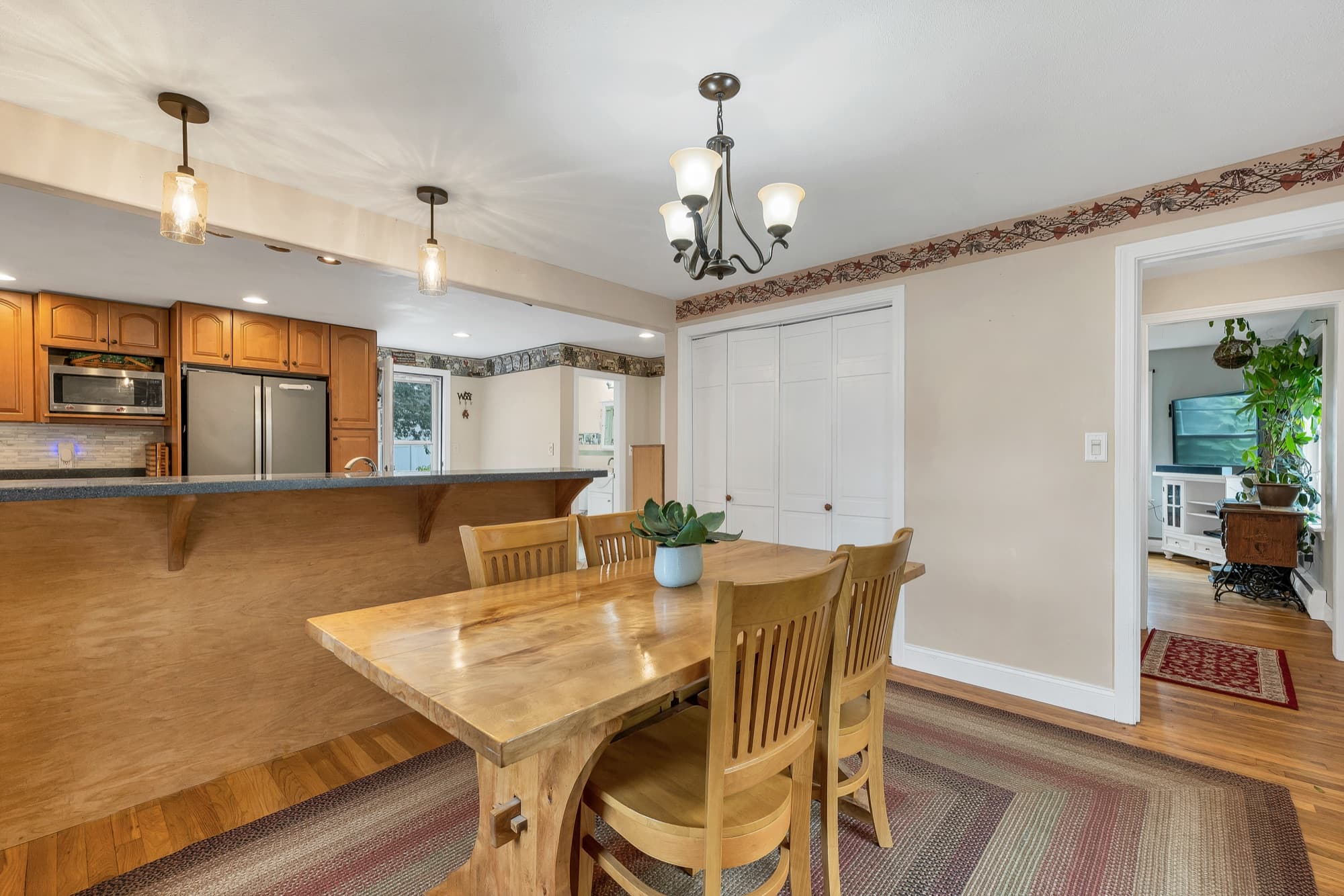Dining area with hardwood floors and a chandelier, open to the kitchen