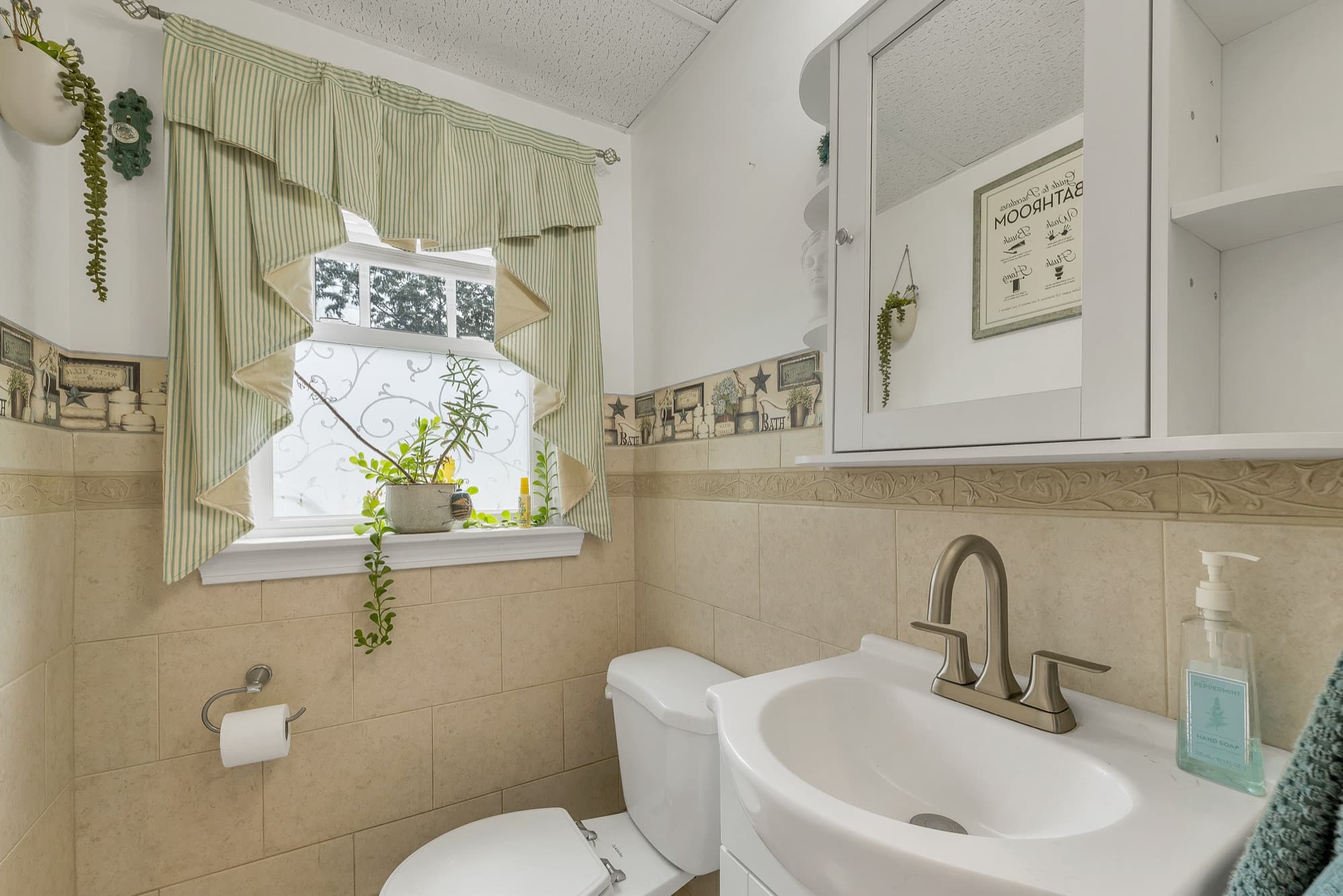 Main-floor half bath with a sink, toilet, and a window