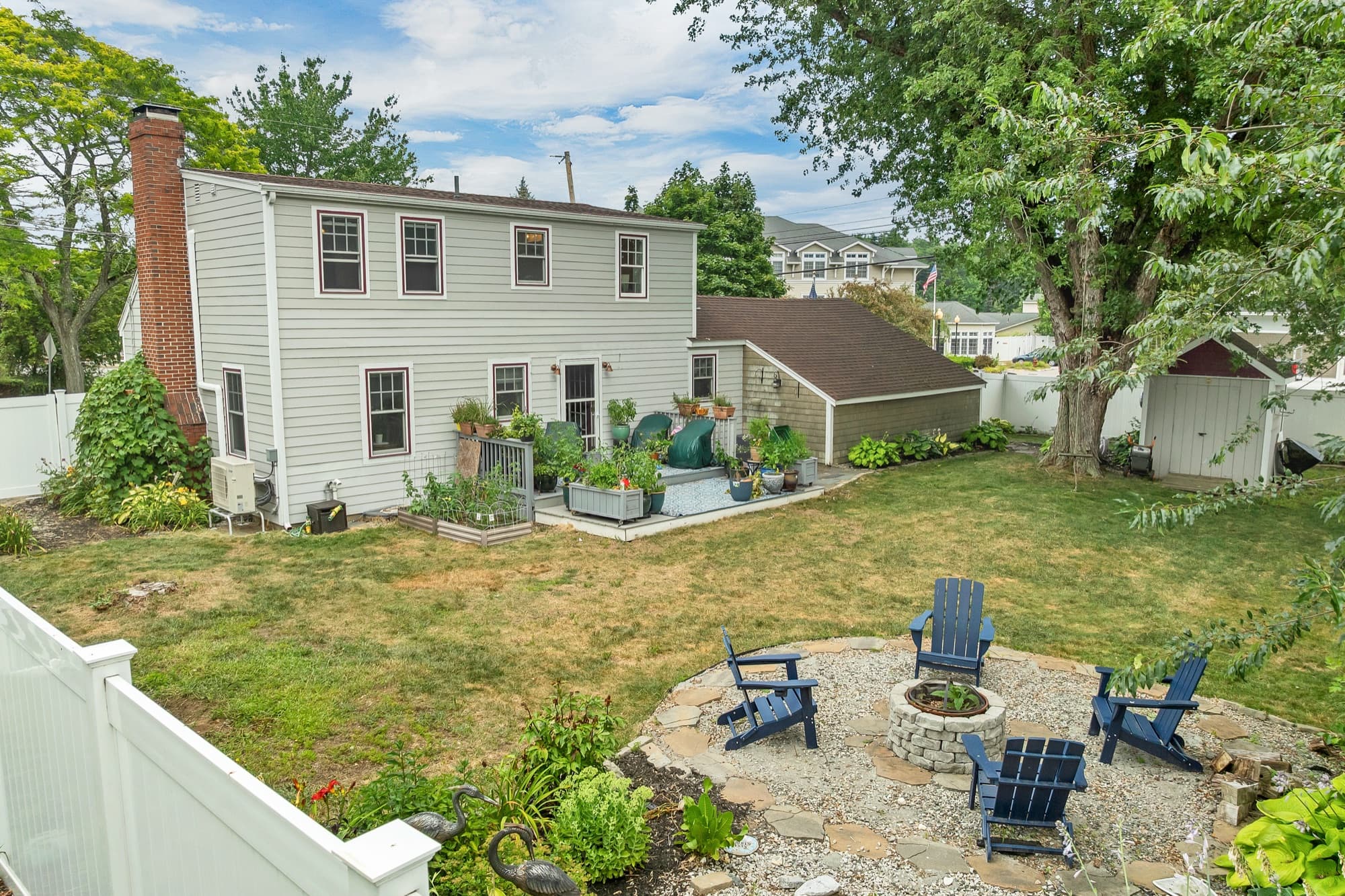 Rear of the house from the fenced backyard, with the fire pit and seating area