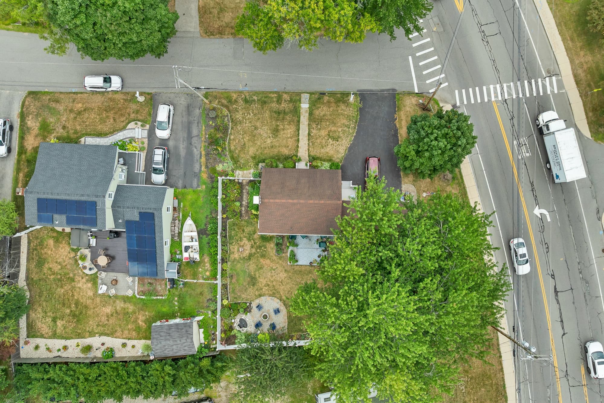 Aerial view of the corner lot, the fenced yard, and the surrounding neighborhood